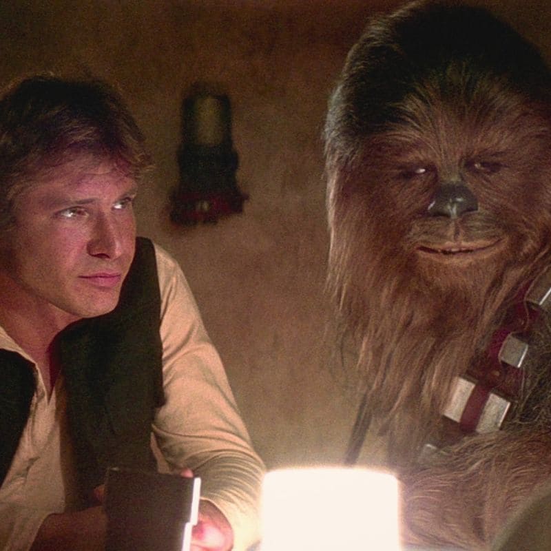 Han Solo et Chewbacca dans une scène intérieure de Star Wars éclairée par une lumière chaude